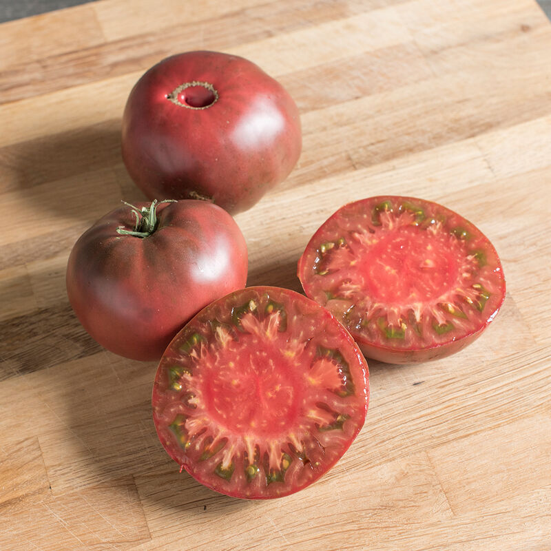 Mature Cherokee Purple tomatoes with dark skin and pink and purple flesh.