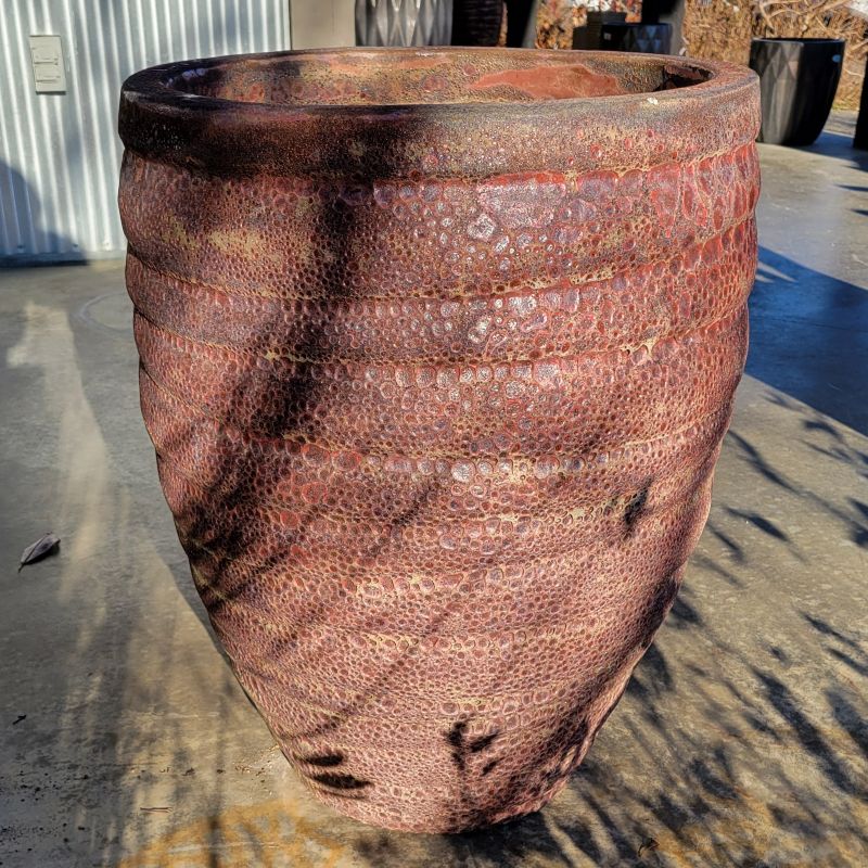 An upright, rounded Guaracha planter with sculpted grooves; finished in a rough textured brick-red glaze with pumice-stone texture.