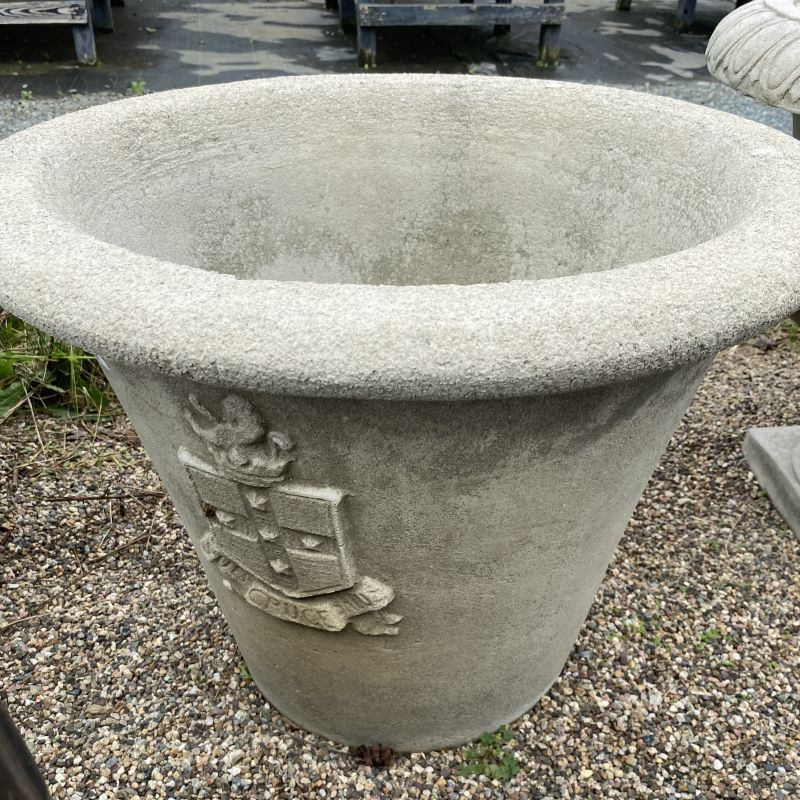 Rolled rim cast-stone Regent Planter with a royal crest decoration on the side.