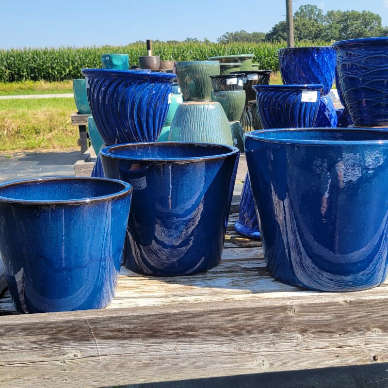 A trio of cerulean blue glazed pots, ranging from small on the left to large on the right.