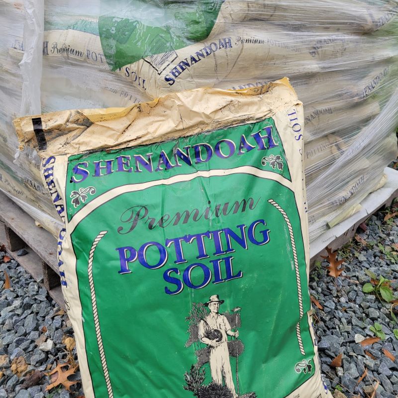 A photo of Shenandoah Premium Potting Soil in a green and beige bag with blue text