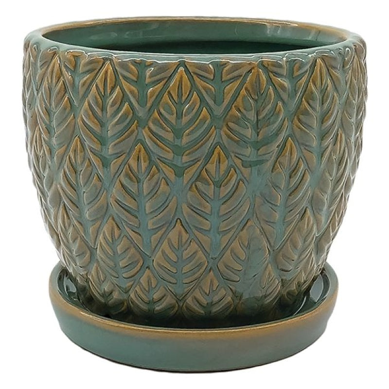 A stock photo of a rounded planter with built-in saucer; the planter's exterior is covered with a sculpted leaf design and finished in a sage green glaze.