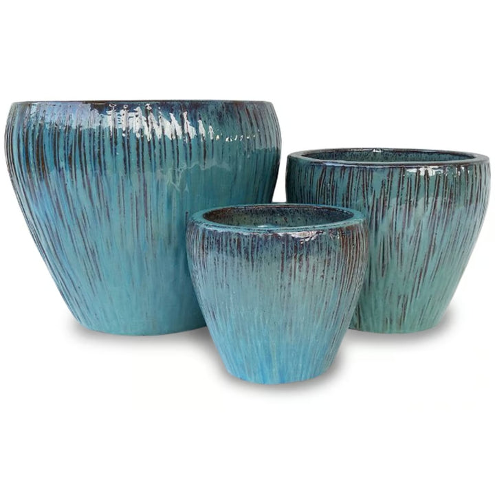 A stock image of a trio of Rounded Tallgrass Egg Pots with lined, grassy design; finished in a Falling Jade blue-green glaze.