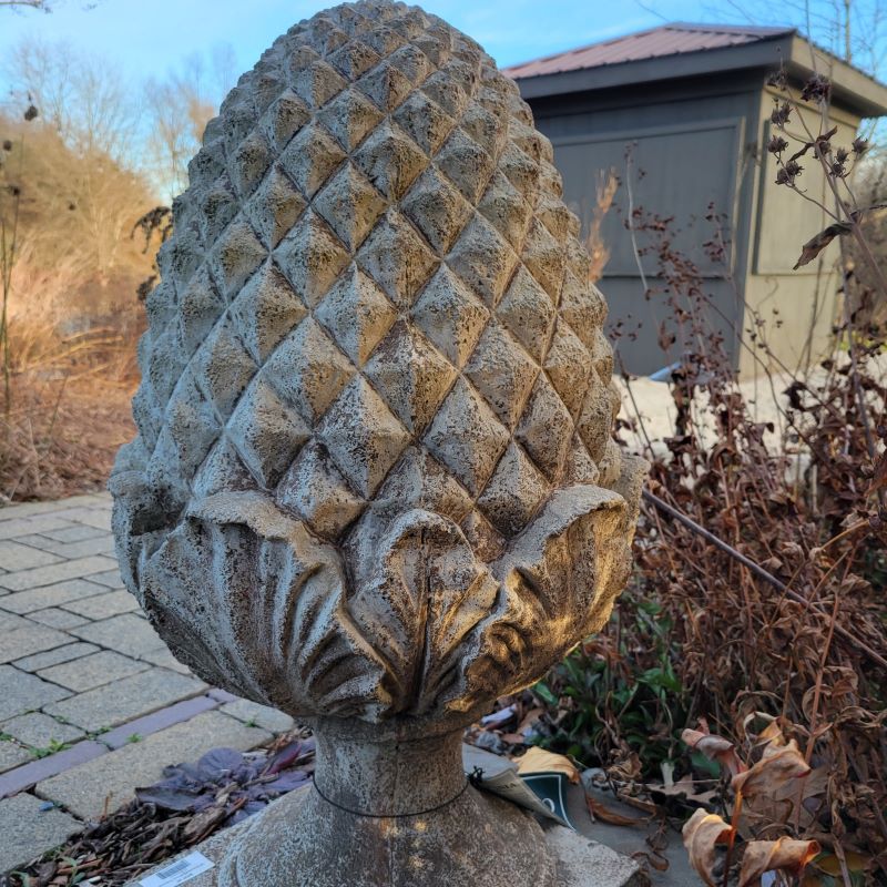 A close-up photo of the textured, cast-stone elements of the Williamsburg Grand Pinecone statue.