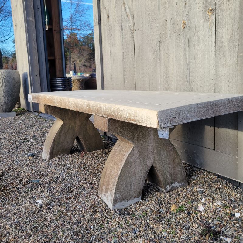 A photo of the flat, rectangular seat and unique, curved, x-shaped supports of The X Bench.