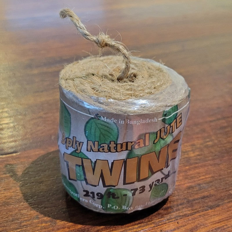 A photo of a plastic-wrapped roll of 3-ply natural jute twine.