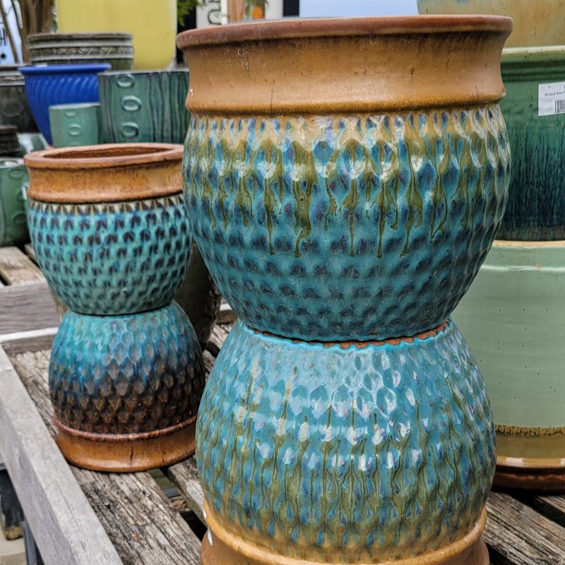 A close-up photo of several Antique Planters with pronounced rim, dimpled design, and two-tone brown and blue-green glaze