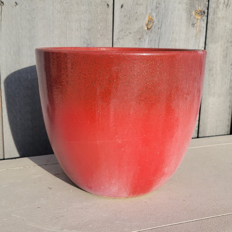 A photo of a bright red and gold-flecked rounded, egg-cup like Athens planter with plain sides.