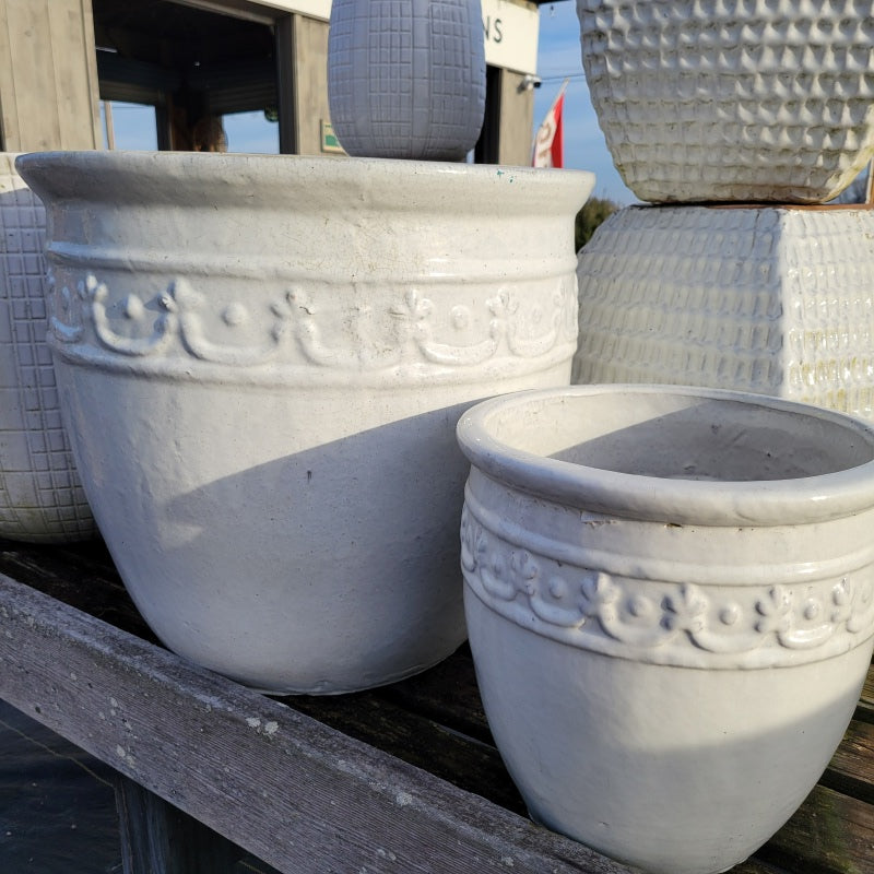 A pair of banded planters, with white glossy glaze and decorative garland designs.