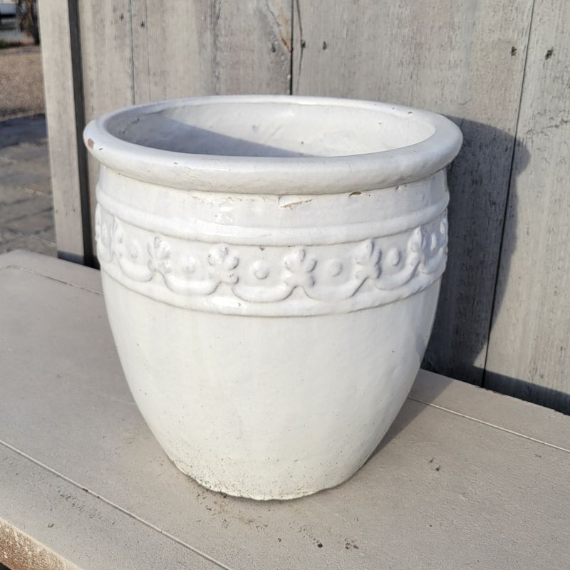 An upright, rounded planter with a decorative band of garland below its pronounced rim; finished with a gloss white glaze.