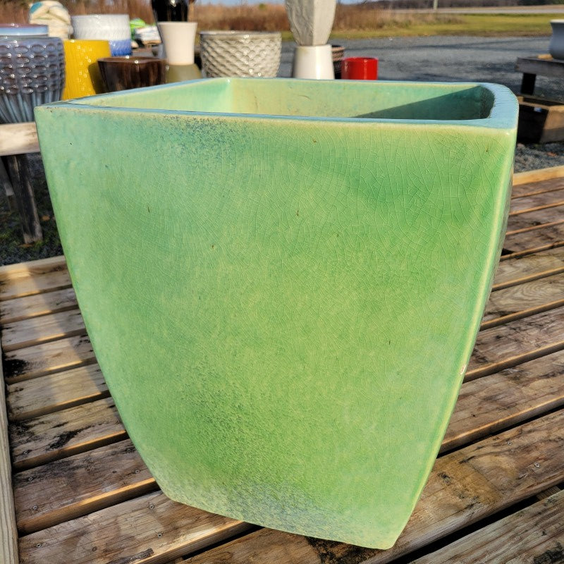 An upright square planter with bowed walls and rounded edges, finished with 'Eau de Nil' pale green glaze.