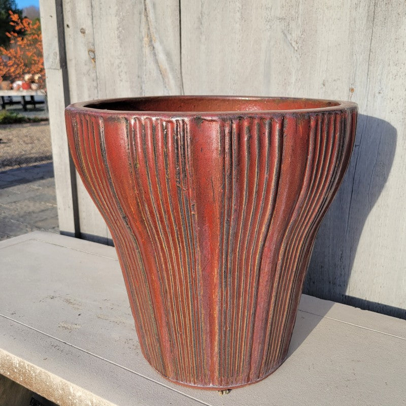 A rounded, flared planter with a brushed fluted design; finished with a metallic brick-red and dark brown glaze.