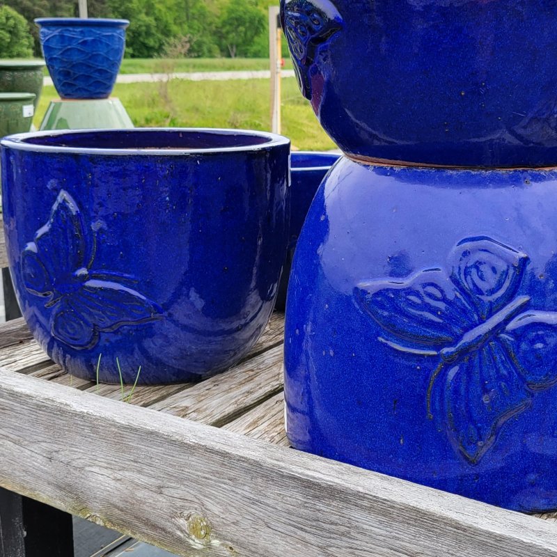 A close-up photo of several Butterfly planters complete with defined butterfly design and deep blue glaze