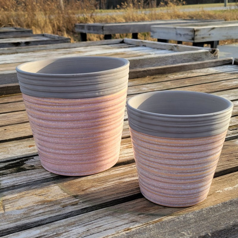 A pair of Cameo P. Pot planters with carved spiral swirl designs and gray/heathered pink glaze.