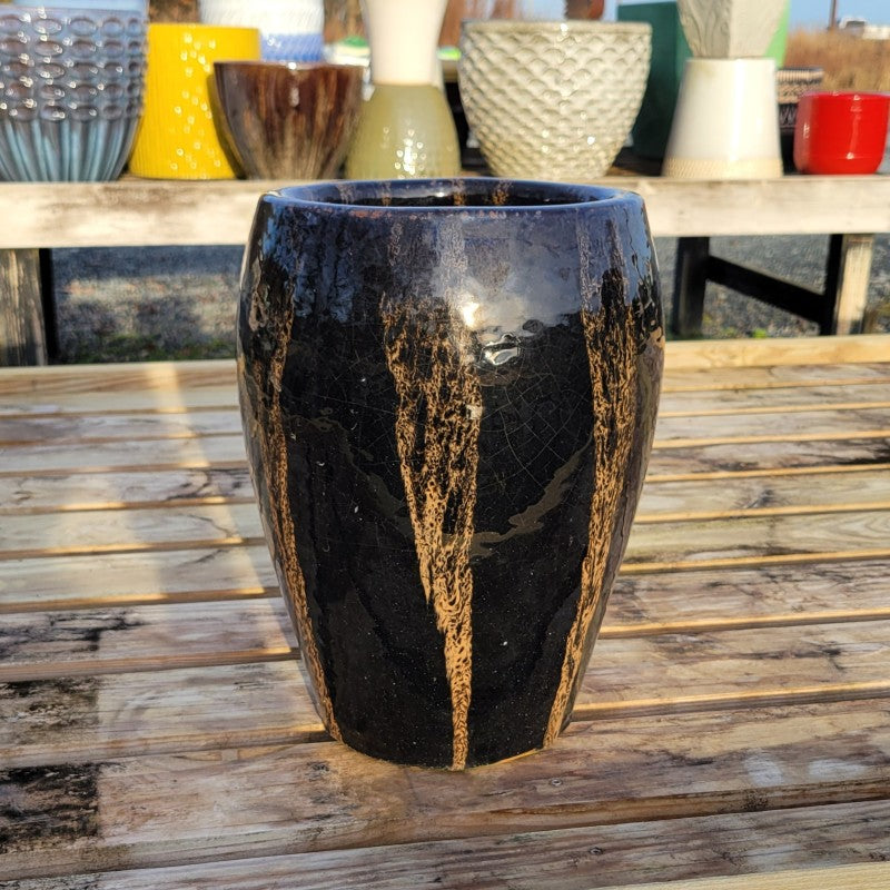 A narrow, vase-like, rounded planter finished with a dark brown glaze and cream-colored accents (color resembles that of a stout beer).