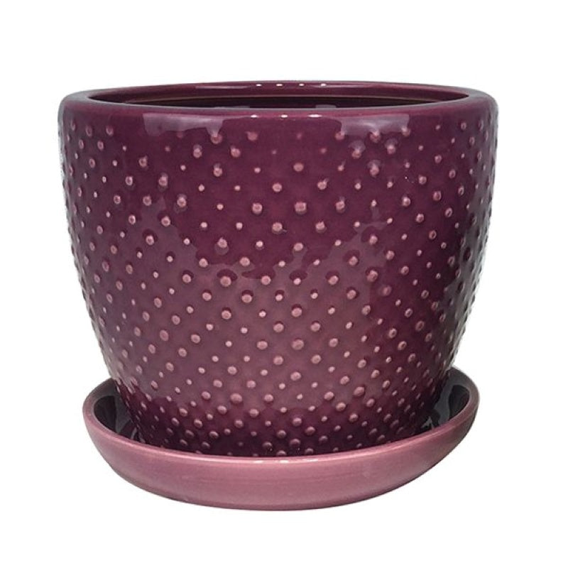 A stock photo of a rounded planter with built-in saucer, decorated with a pattern of larger and smaller raised dots and finished with a lilac purple glaze.