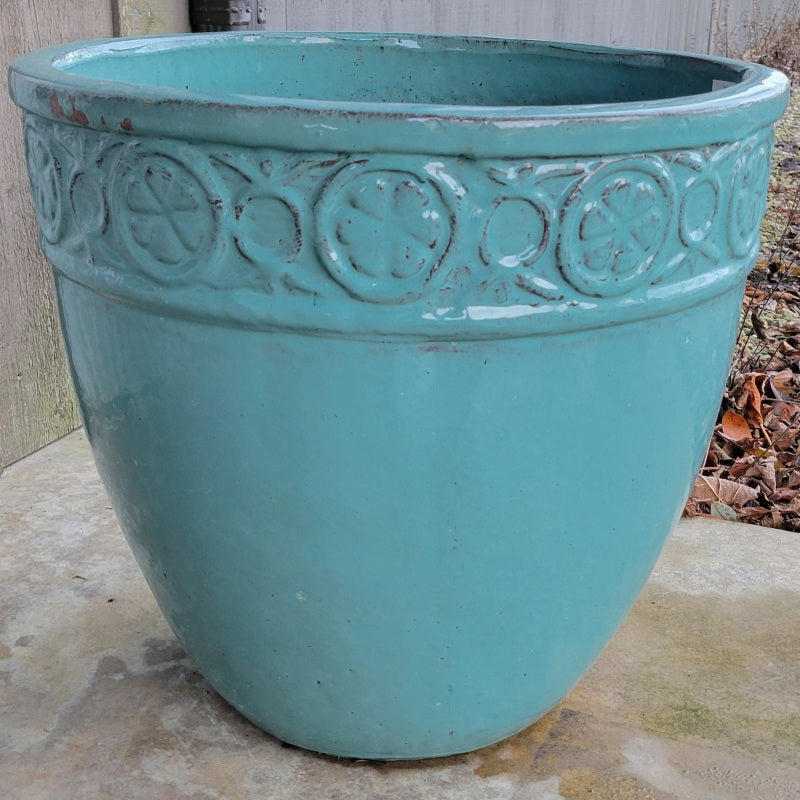 A rounded planter with a decorative band around the rim containing geometric designs and stylized clover motifs; finished in a sky blue glaze.