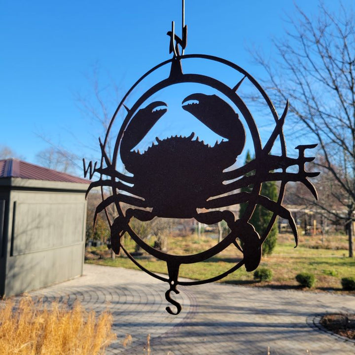 A hanging Compass Crab Metal decoration, with crab and compass rose elements, finished in natural, raw steel.