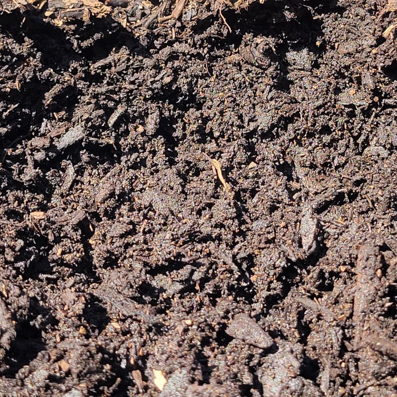 Rich, black compost mix with a variety of coarsely-ground organic materials, perfect for naturally fertilizing garden beds and landscapes.