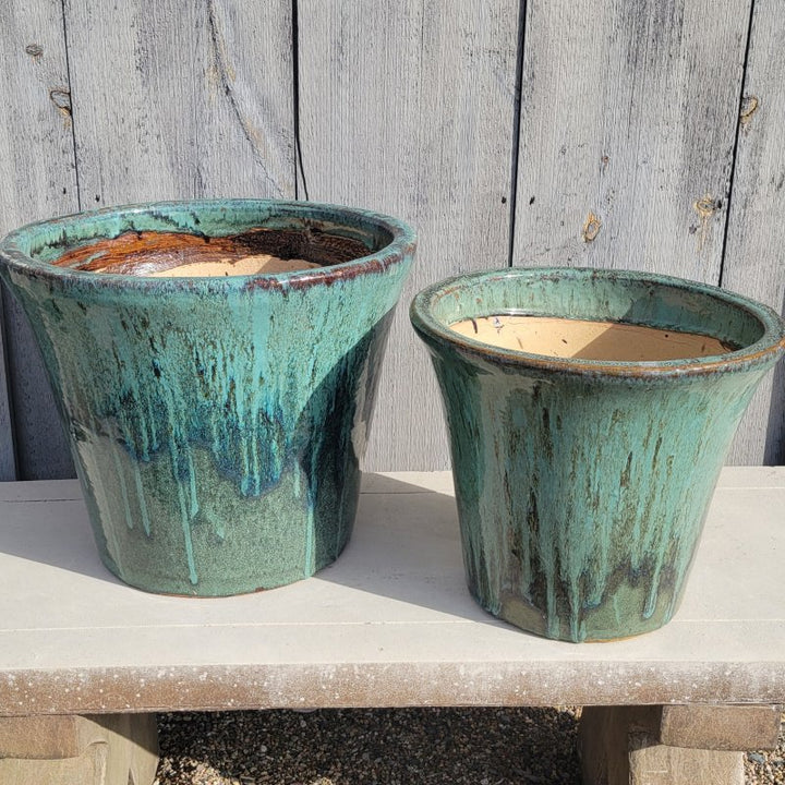 A pair of flared, light and dark green Delphine Planters with size comparison.