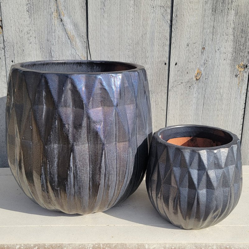 A pair of squat, rounded planters with a sculpted diamond design and a silvery, charcoal gray glaze, placed next to each other for size comparison.