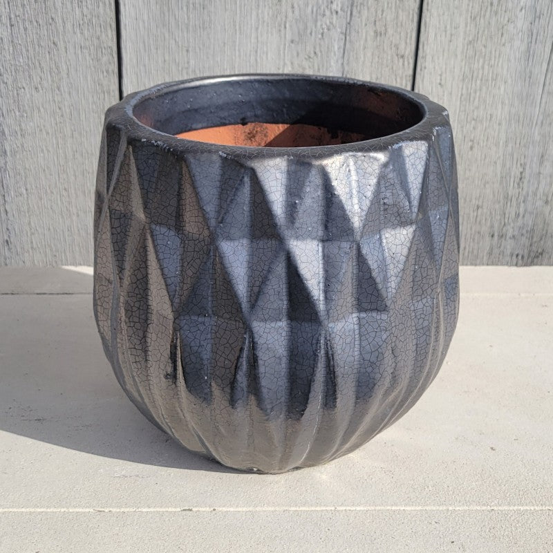 A squat, rounded planter with a sculpted diamond/geometric design and a scalloped lip; finished with a silvery, charcoal gray glaze.