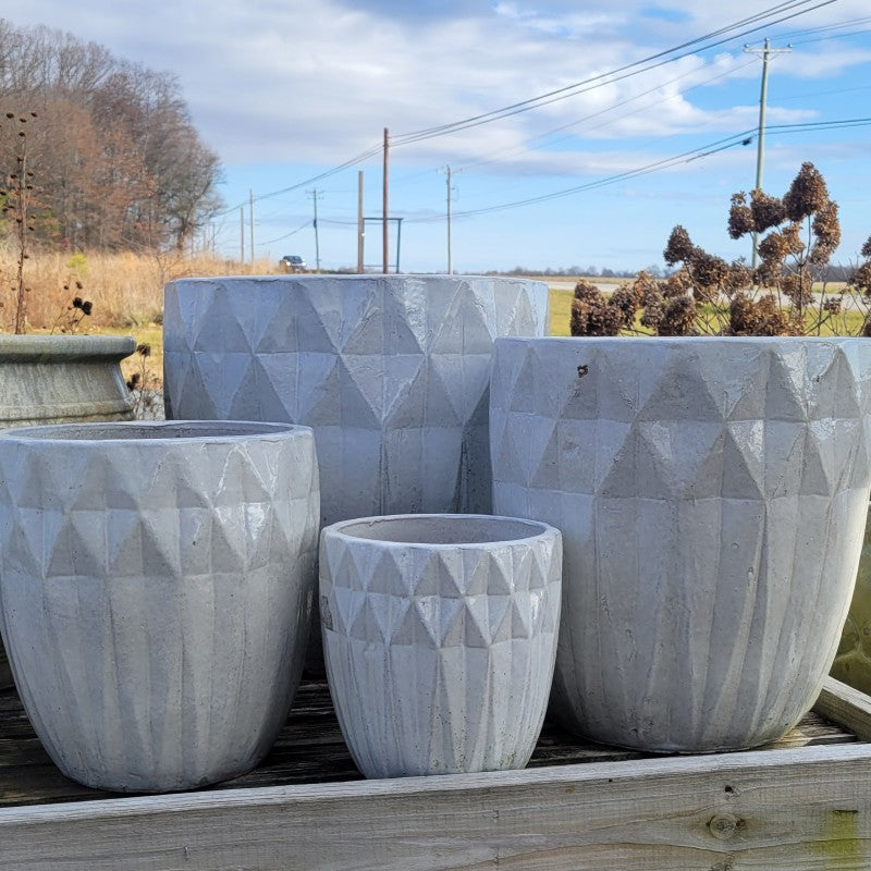 A full set ofnarrow rounded planters with sculpted diamond-shaped texture; placed near each other for size comparison.