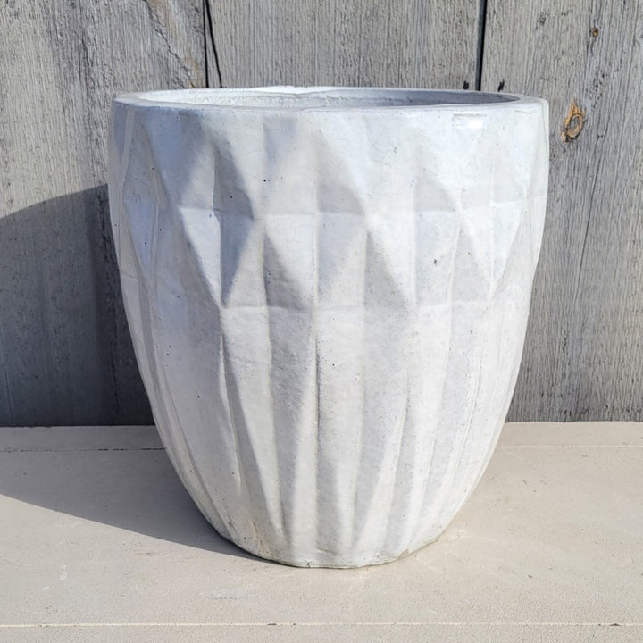 An upright, narrow, rounded planter with sculpted diamond-shaped texture; finished with a gloss white glaze.