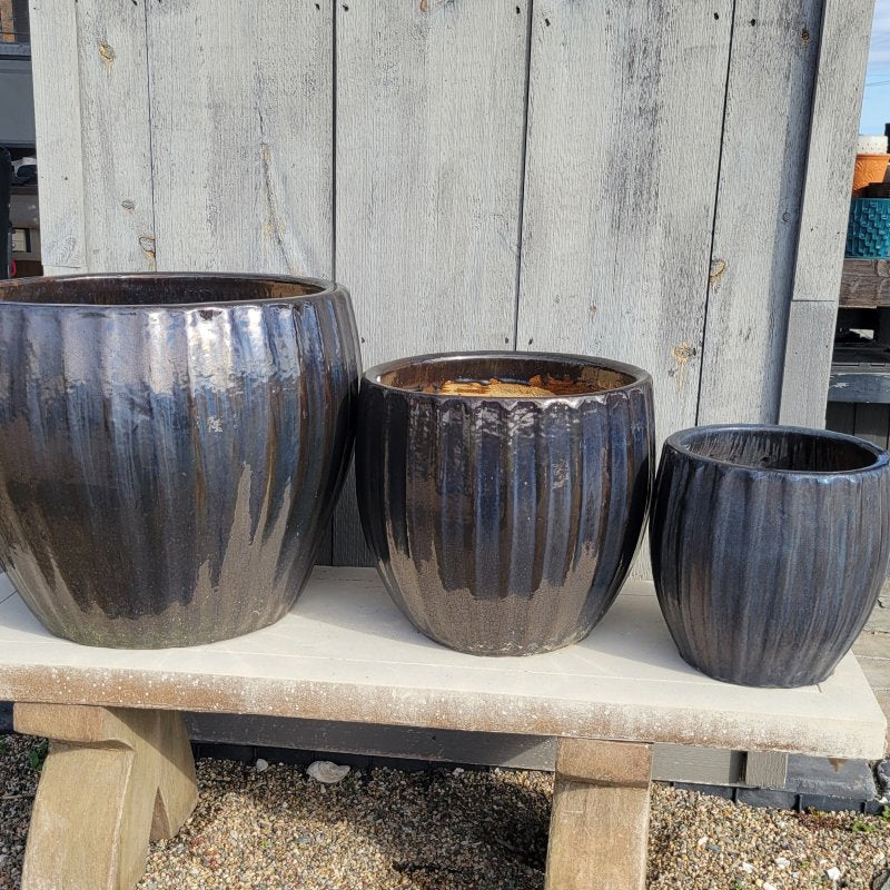 A trio of rounded Estrella Planters with bowed walls and sculpted fluting; finished in a metallic black and pearlescent blue glaze.