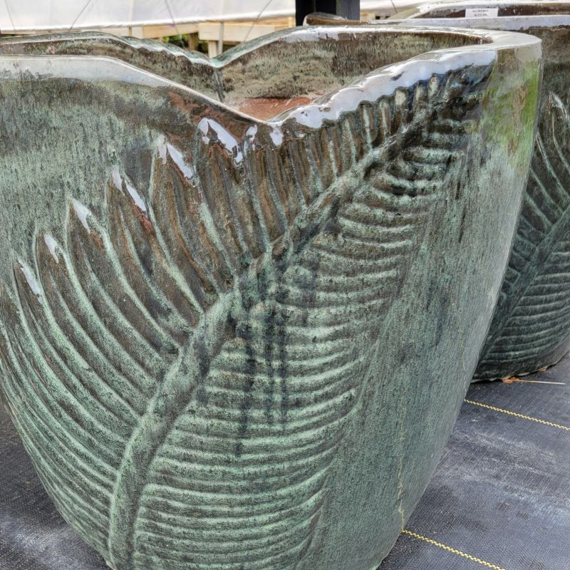 A close-up photo of a Fern Grotto Planter, size XL, with fern motif and natural glaze