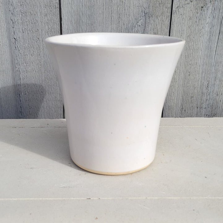 A small, flared, rounded planter finished in a bright, pearly white glaze.