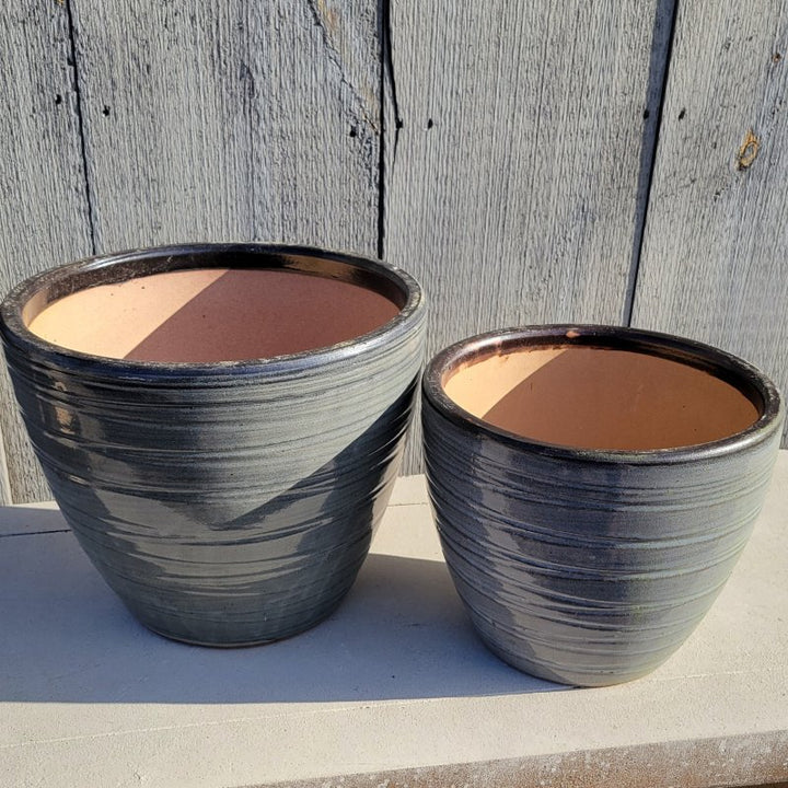 A pair of rounded, egg-cup style Grooved Egg Planters; finished with dark heathered gray glaze; one pot is larger and the other is smaller.