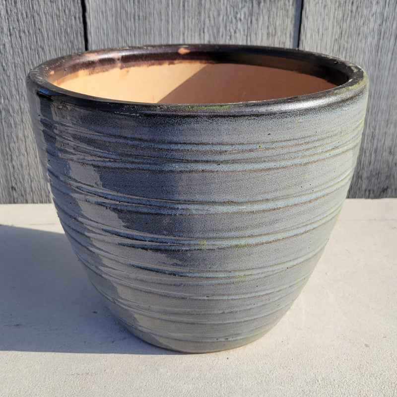 A rounded, egg-cup style planter with a carved spiraling groove design; finished with dark heathered gray glaze.