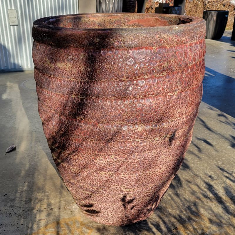 An upright, rounded Guaracha planter with sculpted grooves; finished in a rough textured brick-red glaze with pumice-stone texture.