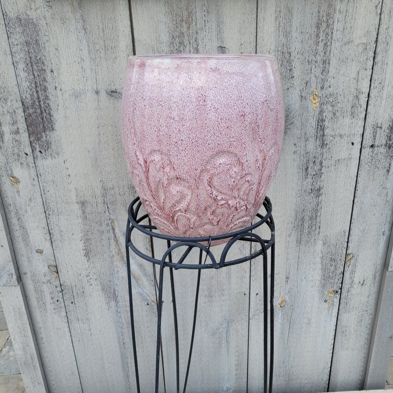 A photo of a Hampton Plant Stand in use, holding a pinkish Dawn Mist planter.