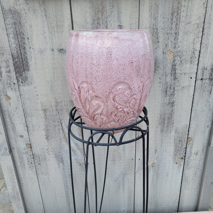 A photo of a Hampton Plant Stand in use, holding a pinkish Dawn Mist planter.