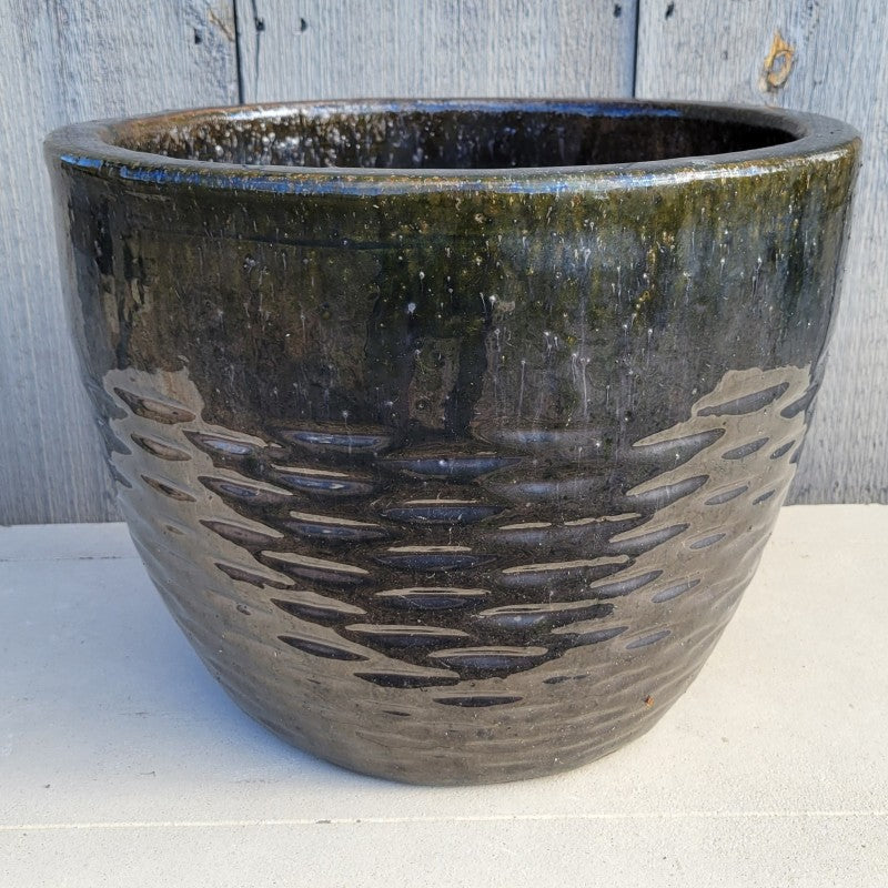 A rounded Hyphen planter with sculpted pattern of dashed lines at the base, finished with pearlescent black-green glaze.