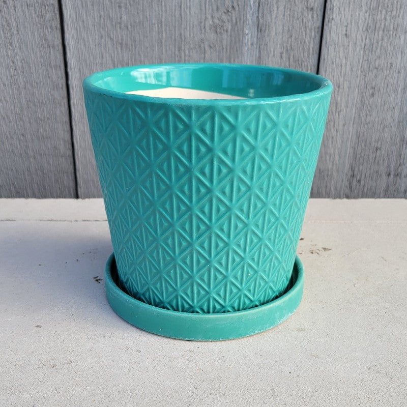 An upright rounded Isosceles planter with built-in saucer and sculpted isosceles triangle design; finished with turquoise glaze.