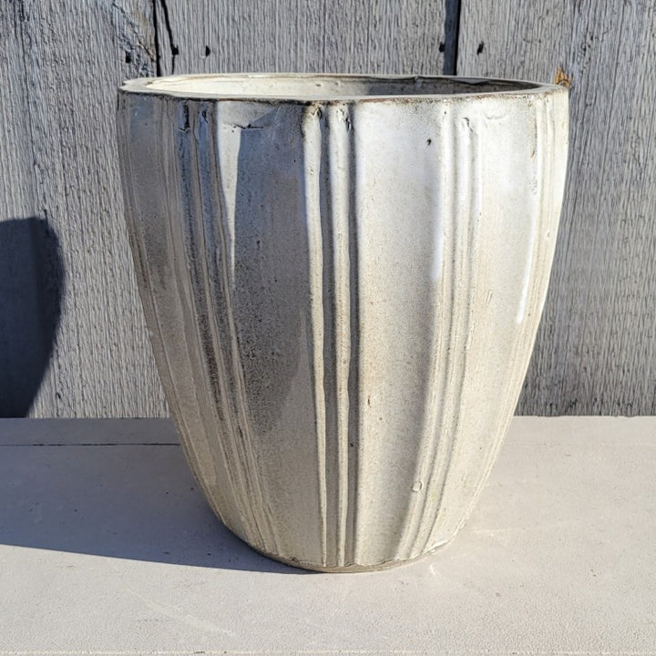 An upright, rounded Lucien planter with a fluted exterior, finished in a heathered cream-white glaze.