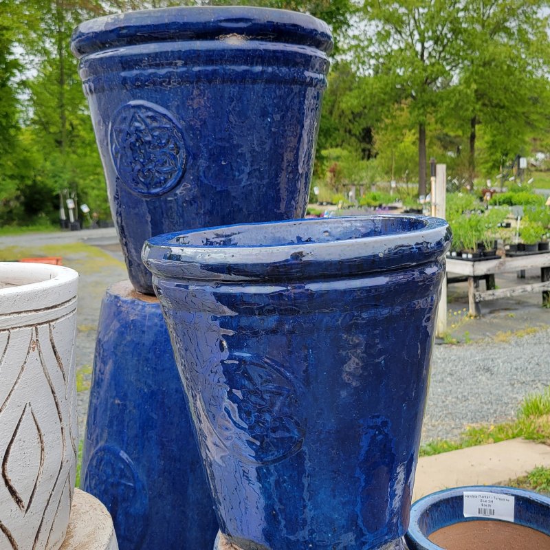 A close-up photo of two glossy, dark blue Mandala Planters