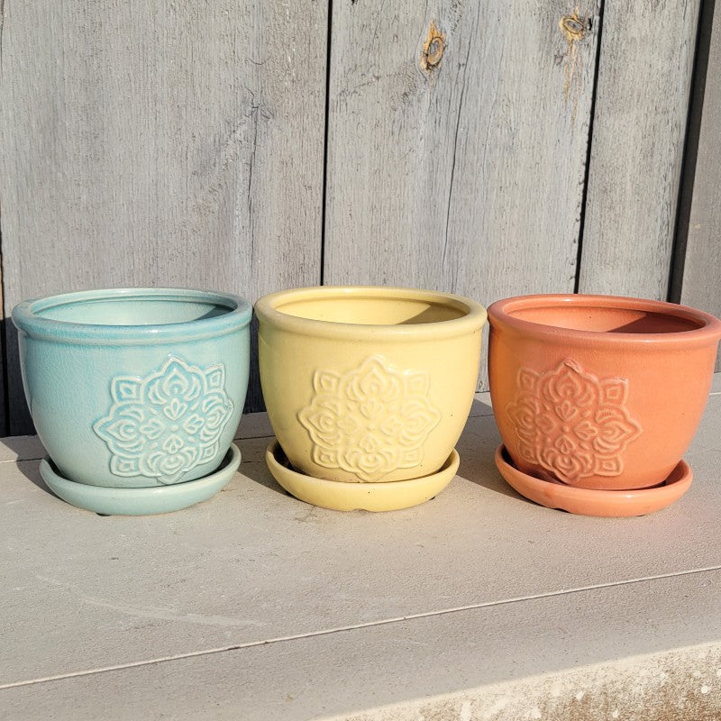 A trio of small, mandala-inspired Medallion planters, finished with light blue, yellow, and orange glazes.