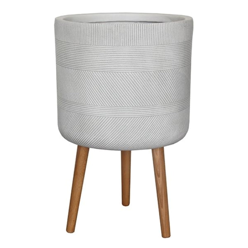 A stock photo of a straight-walled rounded planter with sculpted/carved herringbone pattern and a matte, pale-gray finish; pot sits atop a built-in wooden tripod base.