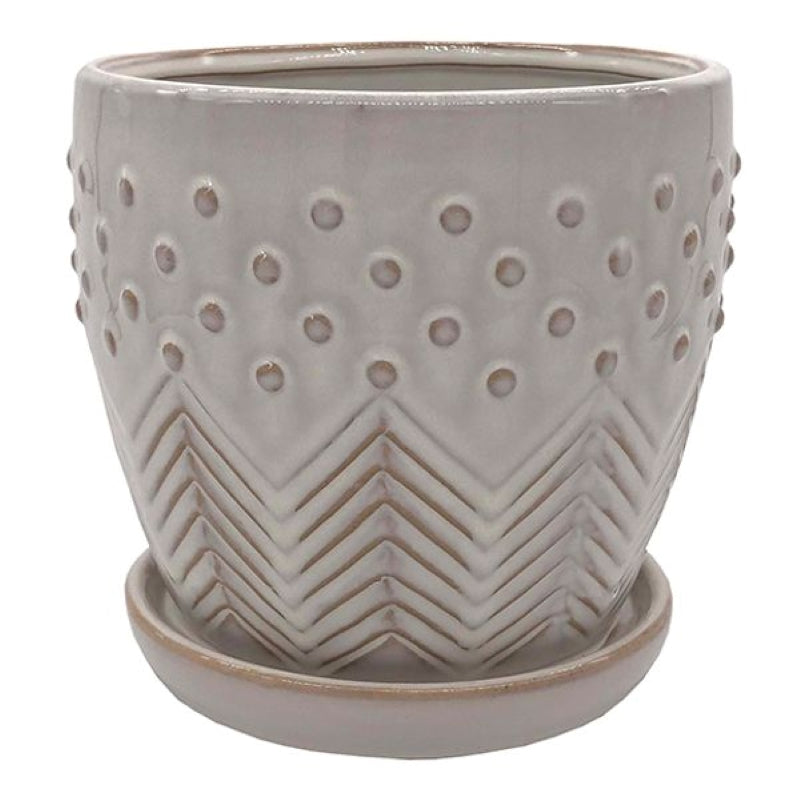 A stock photo of a rounded planter with built-in saucer and a multi-piece design with carved groove and sculpted dot elements; finished in a cream white glaze.