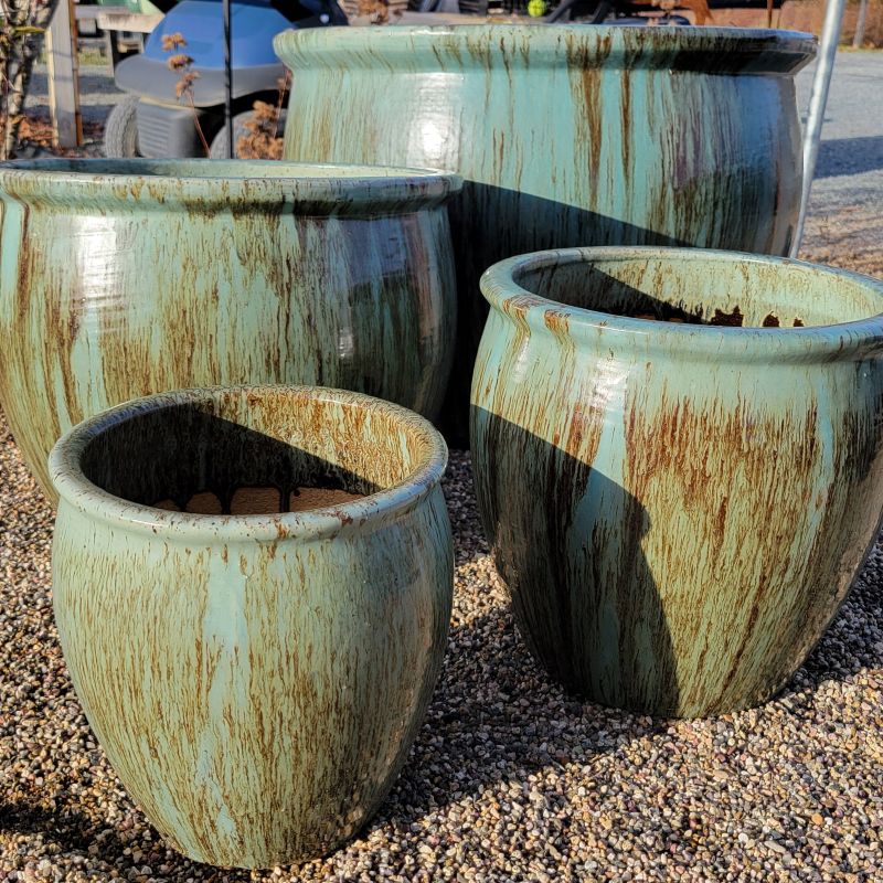 A set of four rounded planters with pronounced rims; smaller planters are narrow and upright, while larger planters are more spherical. Small, medium large, and extra large planters are all finished with a sea-foam/jade green 'Glacier' glaze.