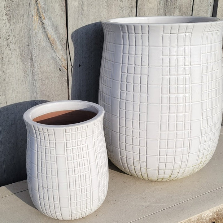 A pair of upright, urn-like Neptune's Cousin planters, one small and one large, finished with a geometric line design and white glaze.