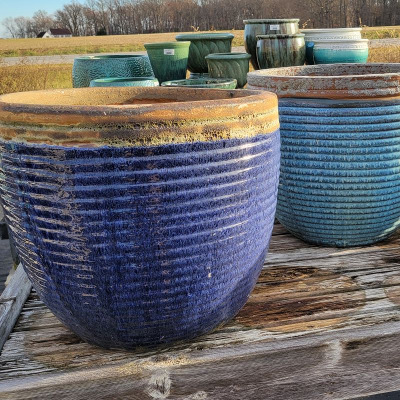 A pair of large, round Nevis planters decorated with regularly spaced sculpted rings; finished with a sea-blue glaze around the lower part and a sand-colored pumice-stone glaze at the rim, resulting in a beachy appearance.