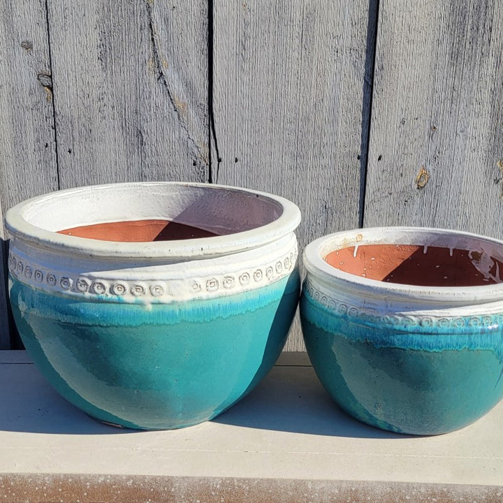 A pair of rounded Ombre Planters with a decorative band of spiral designs under the lip; this finish is teal-green and white, and comes in sizes Extra Large and Large.