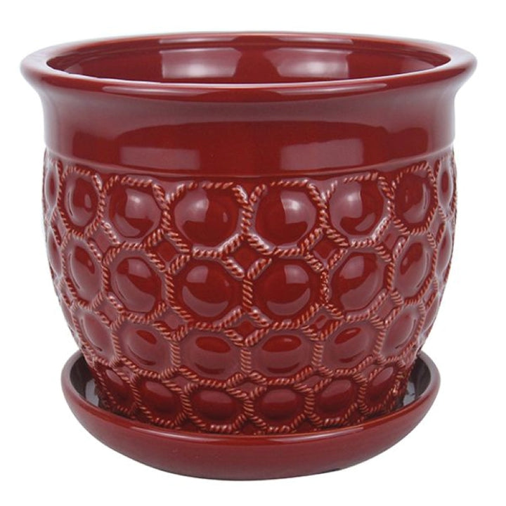 A stock photo of a small, rounded planter with built-in saucer and a sculpted net and bubble pattern; finished in a dark red glaze.