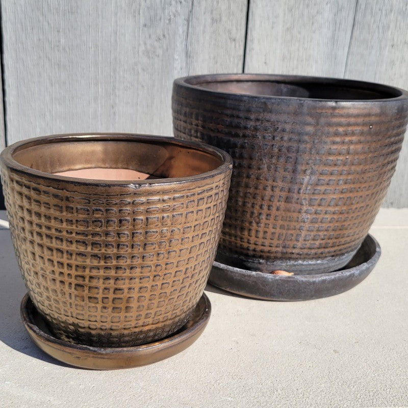 A pair of Pincheck P. Pots placed next to each other, one smaller and one larger. Both are finished in a dark, metallic bronze glaze.