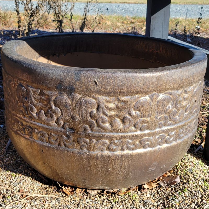 A squat, rounded Quebrada planter wrapped with a sculpted faux-Mesoamerican design and finished with a matte, weathered-bronze glaze.